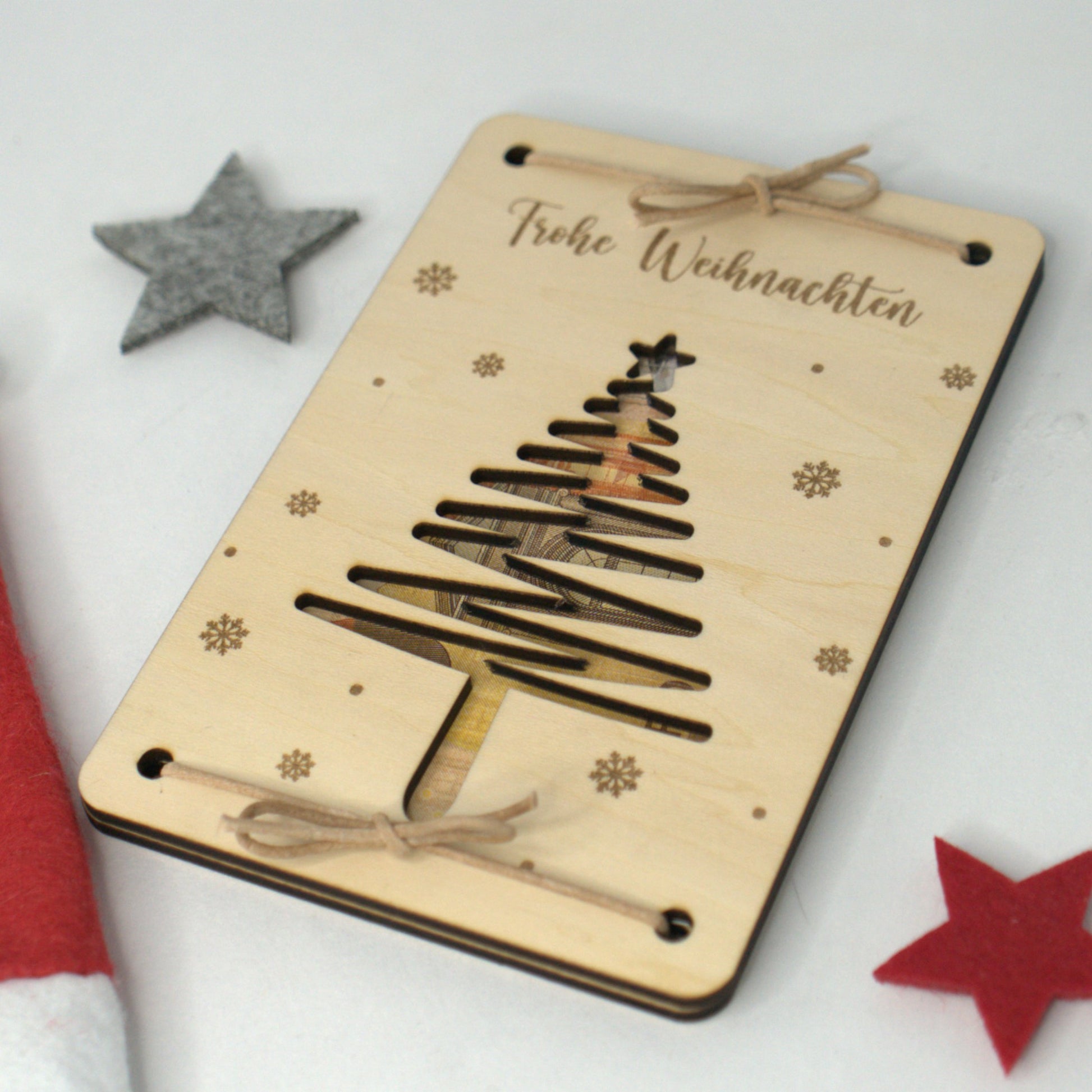 Holzkarte als Weihnachtsgeldgeschenk mit Tannenbaum und Schnur – Frohe Weihnachten Gravur, Geldschein sichtbar eingelegt.