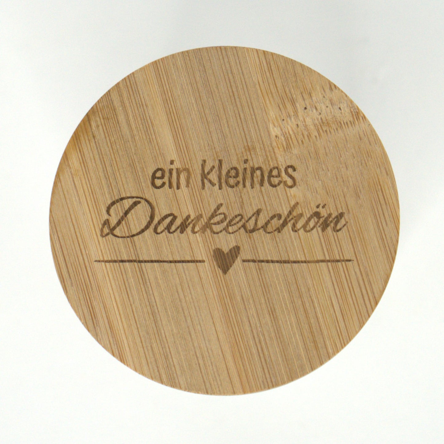 Nahaufnahme der Gravur „ein kleines Dankeschön“ auf dem Bambusdeckel des Geschenkglases.