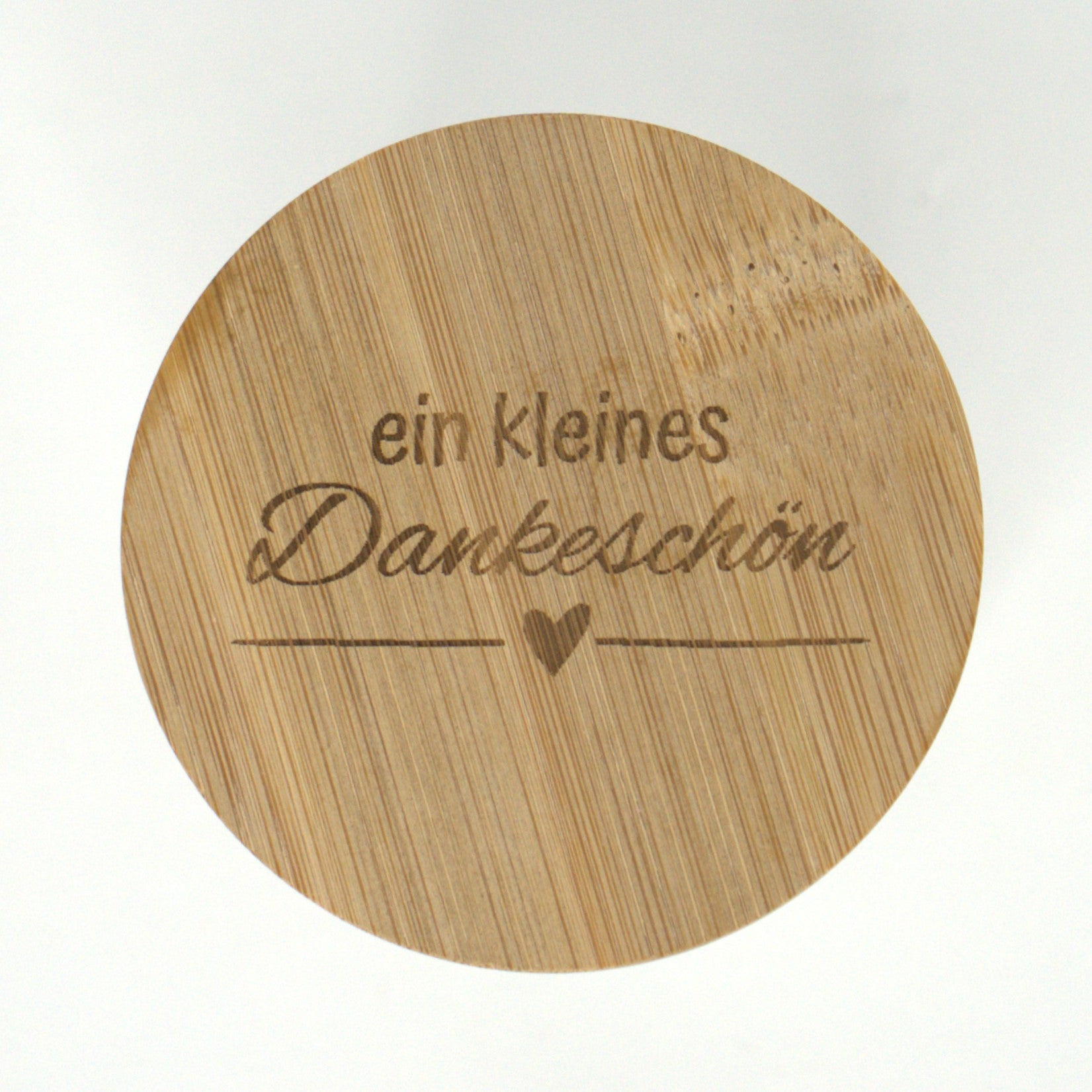 Nahaufnahme der Gravur „ein kleines Dankeschön“ auf dem Bambusdeckel des Geschenkglases.