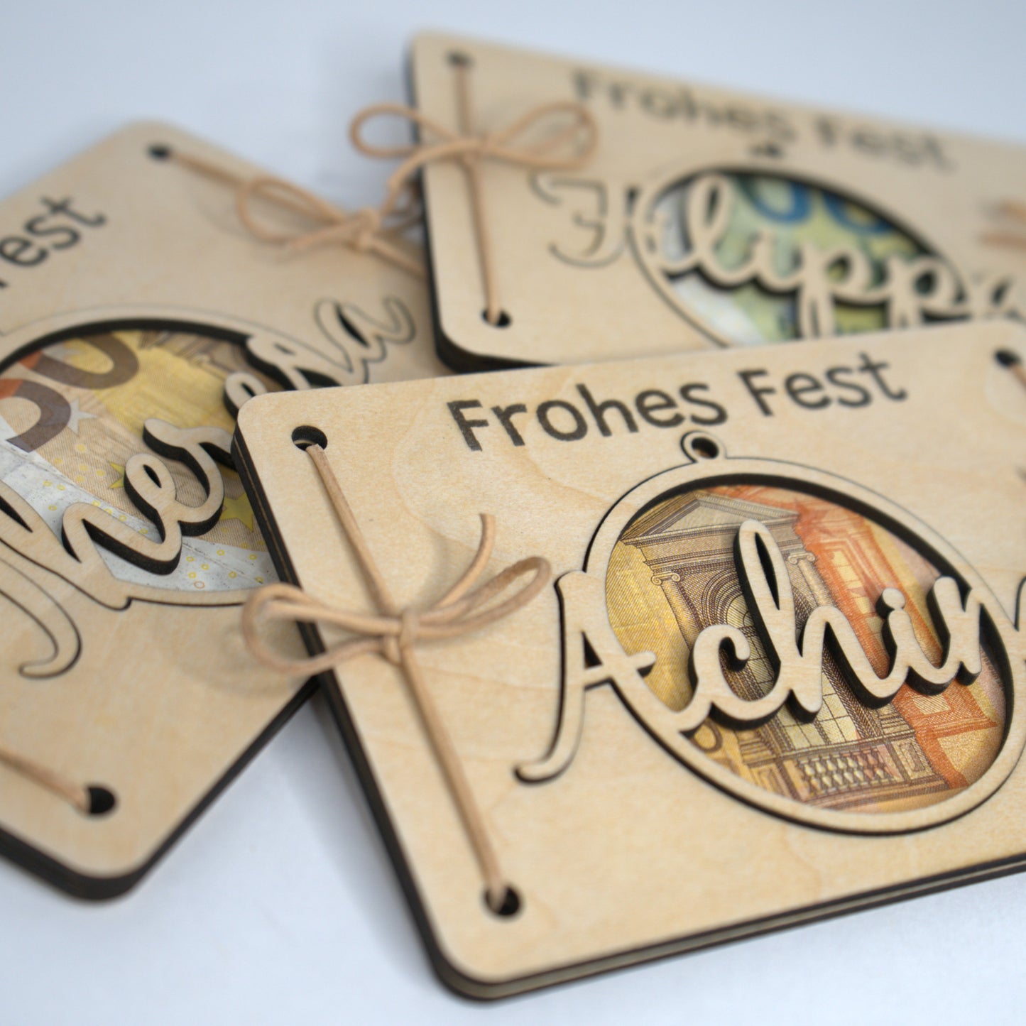 Individuelle Geldgeschenke Weihnachten aus Holz – verschiedene Namen als personalisierte Weihnachtskugeln.