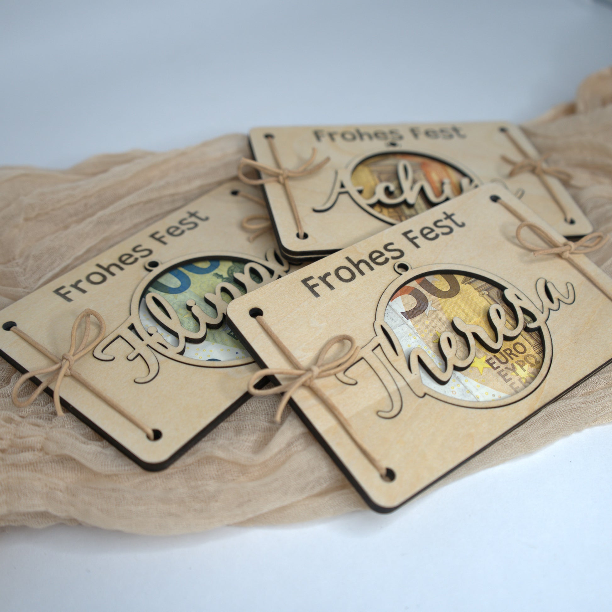 Holz-Geldgeschenk Weihnachten mit graviertem ‚Frohes Fest‘ und personalisierter Namenskugel – Einzelteile und Kordel.
